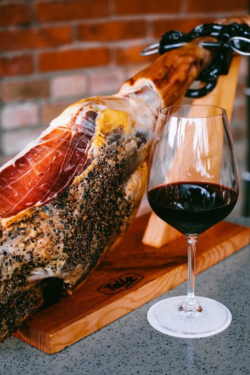 Photo of a Glass of Wine Beside Jamon