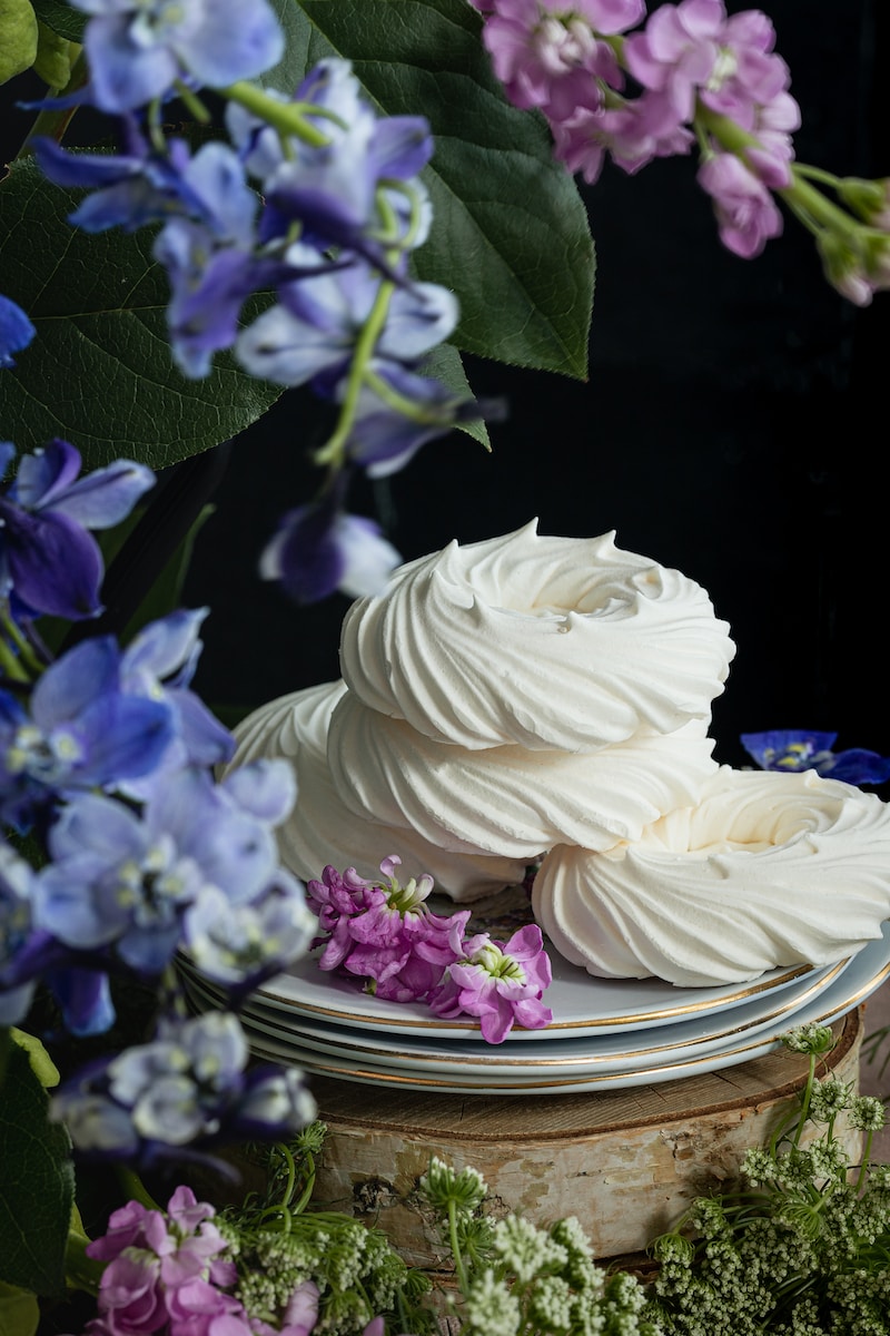 a cake with white frosting and purple flowers